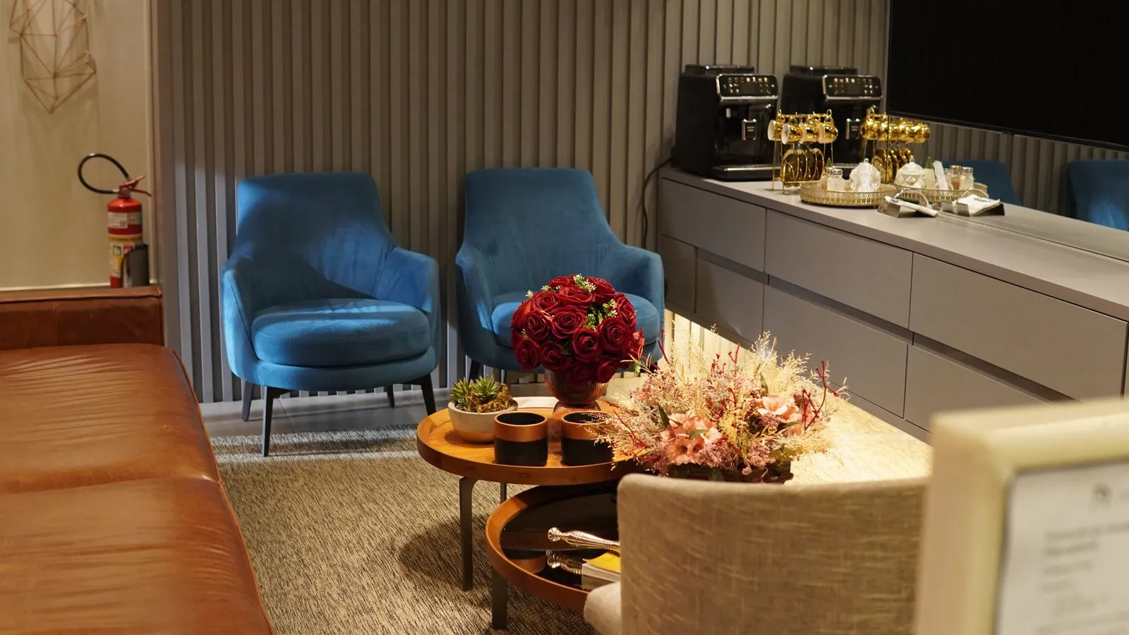 Sala de espera com poltronas azuis e flores