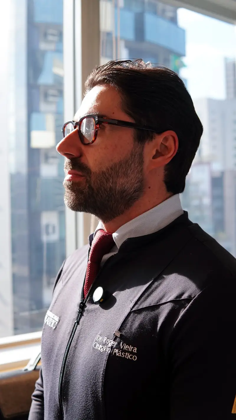 Dr. Roger Vieira olhando pela janela da clínica