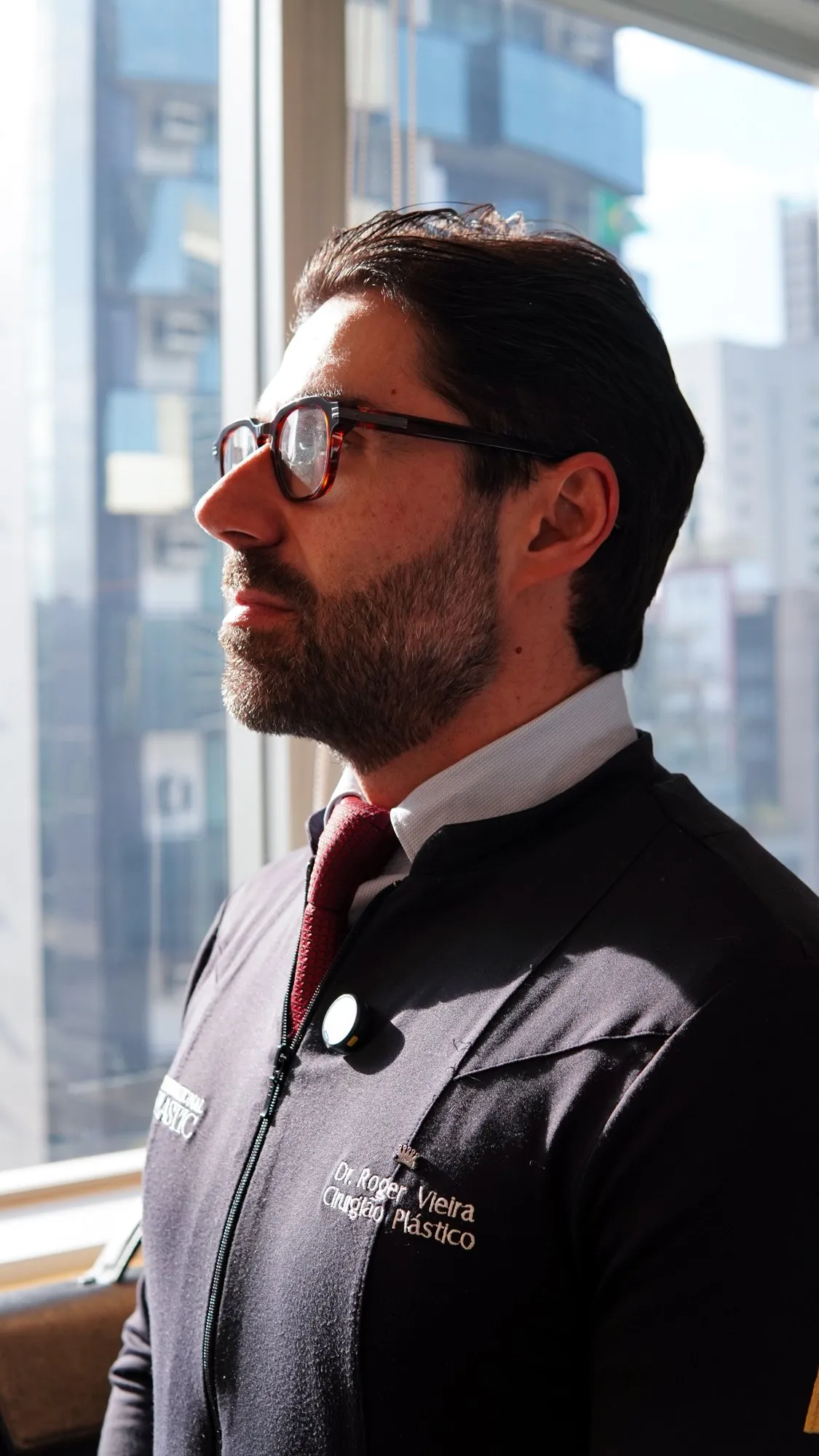 Dr. Roger Vieira olhando pela janela da clínica